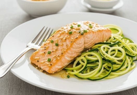 Garlic Butter Salmon with Zucchini Noodles on a white plate