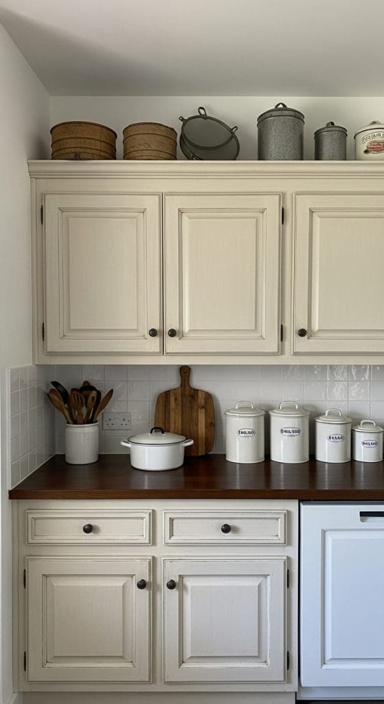 vintage pots and pans on top of kitchen cabinets