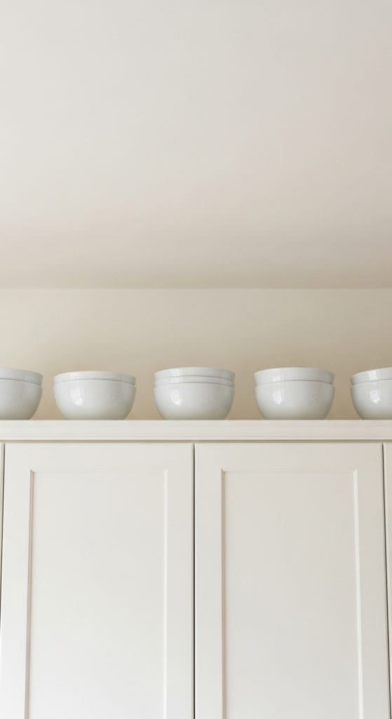 matching white bowls on top of kitchen cabinets