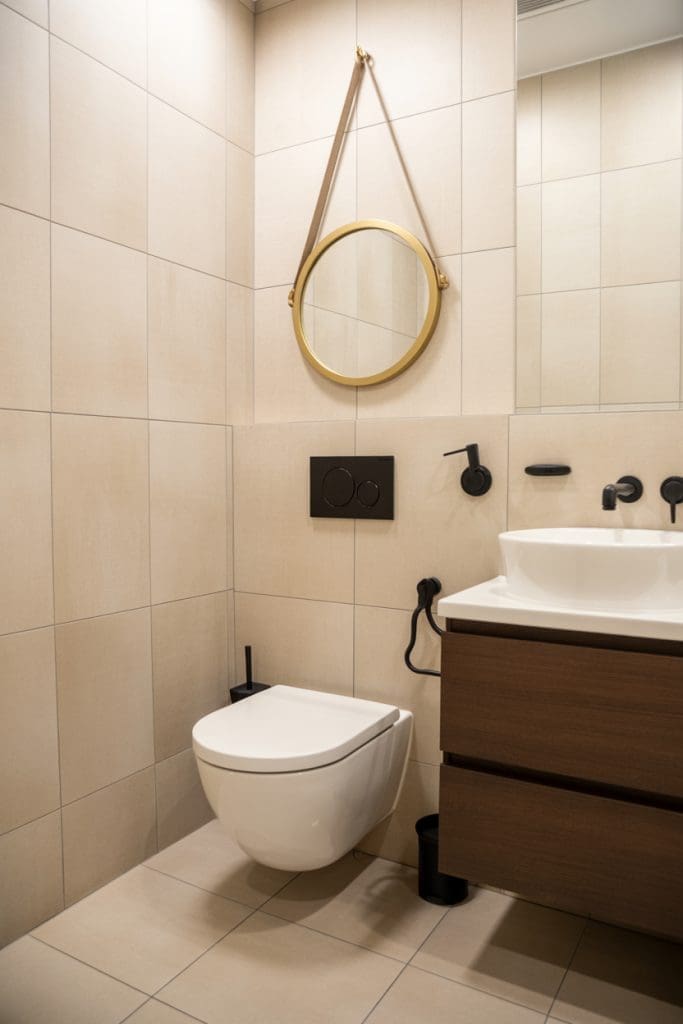 gold mirror behind the toilet