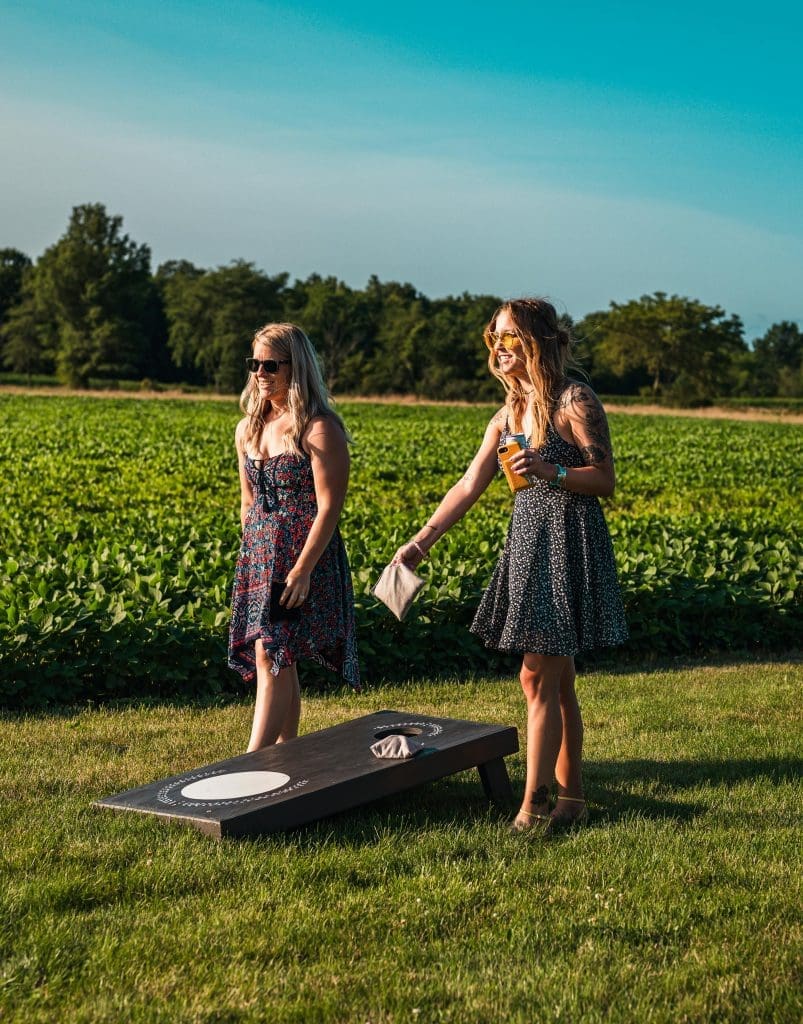 two women playing yard game cornhole