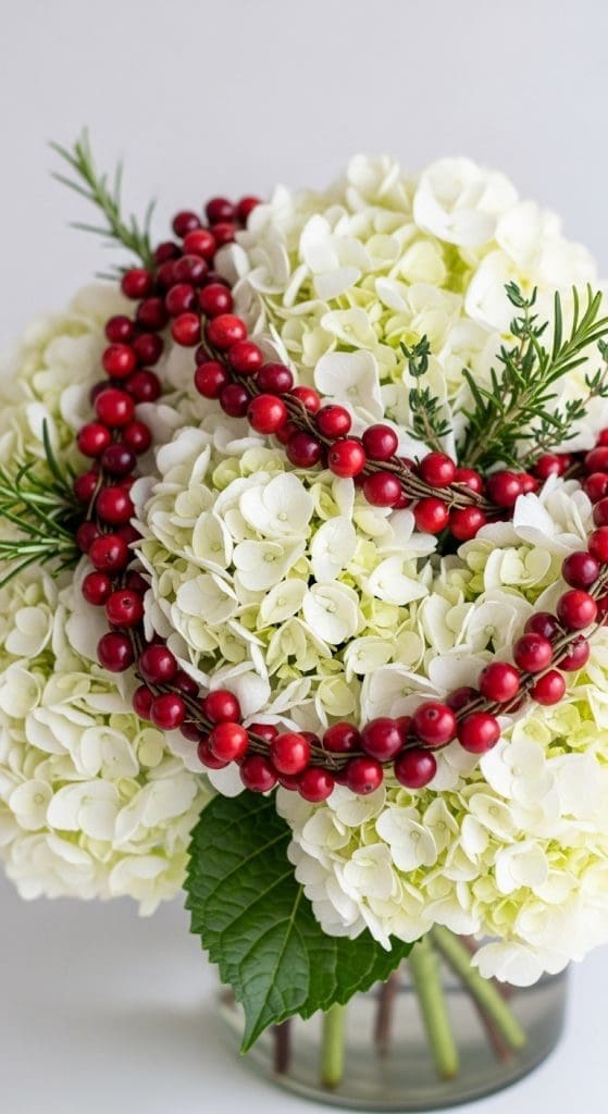 hydrangeas with cranberry wreath wrapped around flowers in a low vase