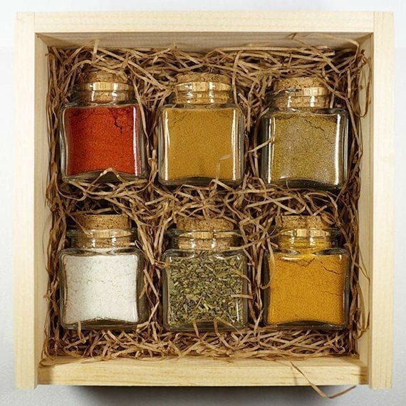 box filled with mini jars of festive spices Thanksgiving Gift Basket idea