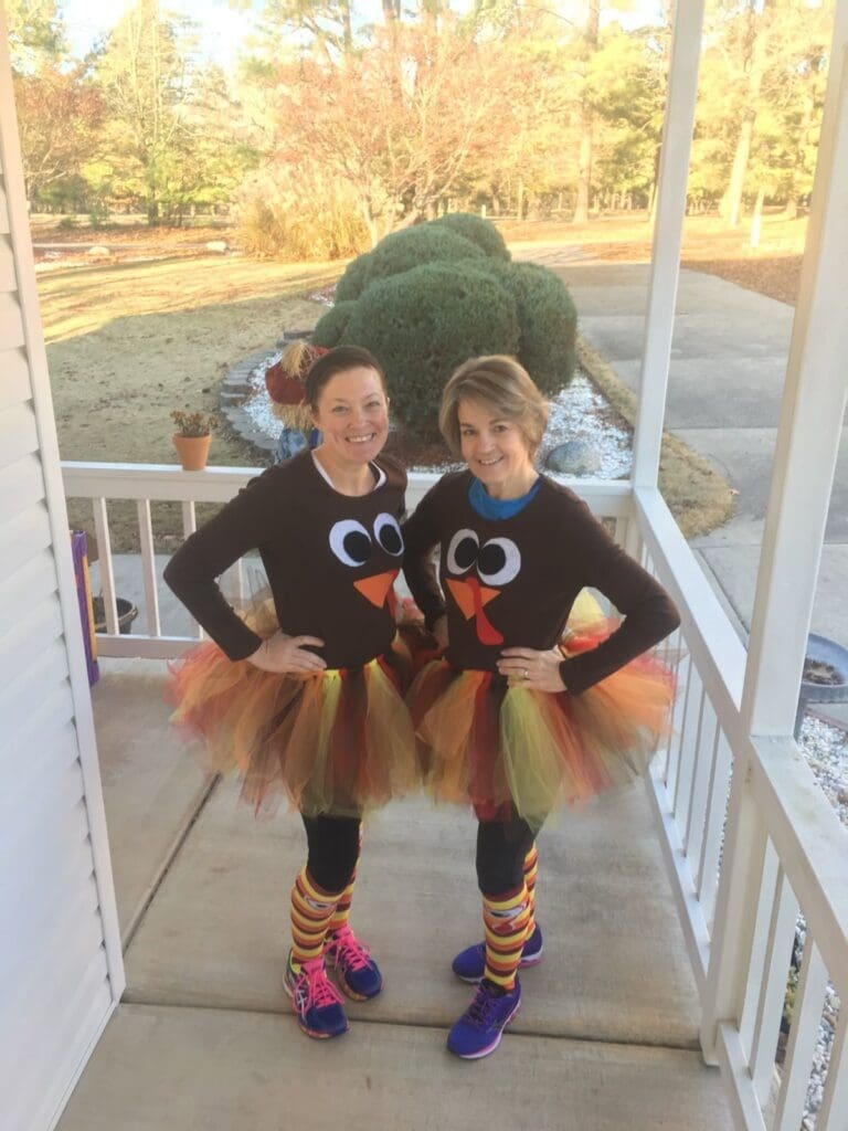 Two women dressed up for a turkey trot mini walk Thanksgiving entertainment ideas